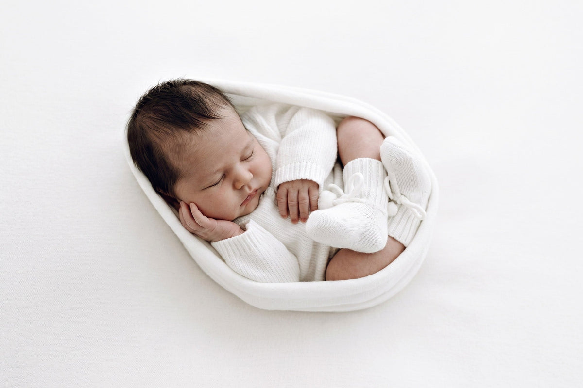 Newborn photography wrap styled in a soft neutral newborn photography setup